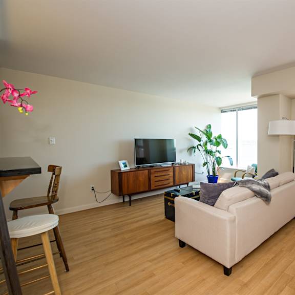 a living room with a white couch and a wooden entertainment center.