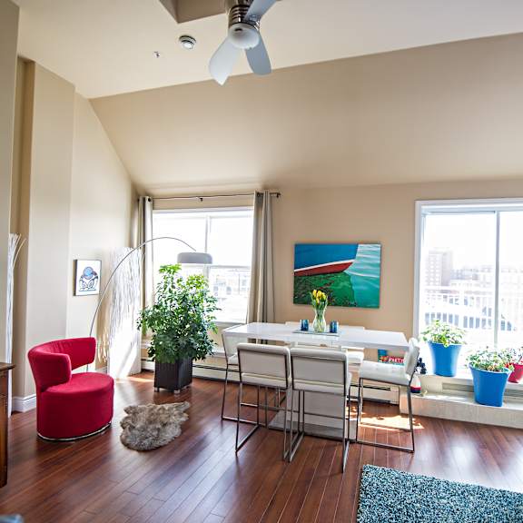 a living room with a red chair and a white couch.