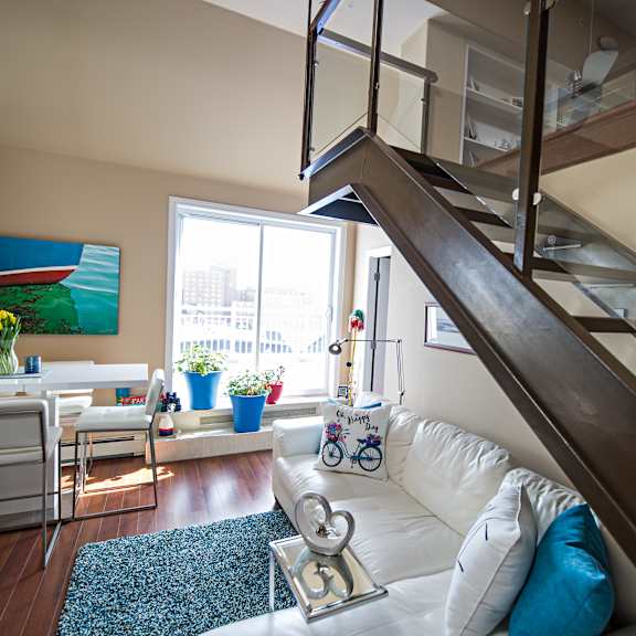 a living room with a white couch and a painting on the wall.