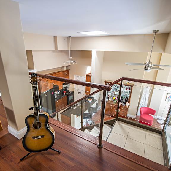 a guitar sits on a stand in a living room.