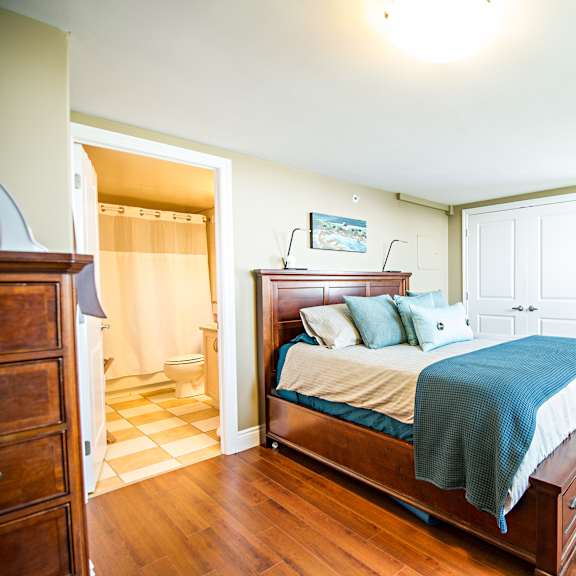 a bedroom with a bed, nightstand, and dresser.
