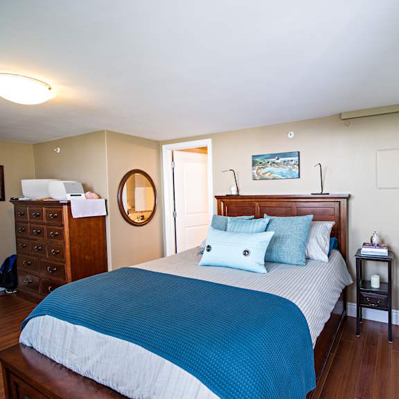 a bedroom with a bed, nightstand, and dresser.