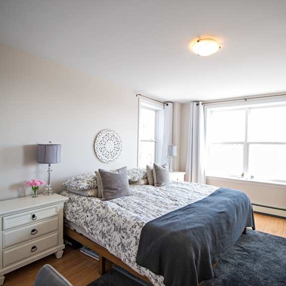 a bedroom with a bed, nightstand, and window.