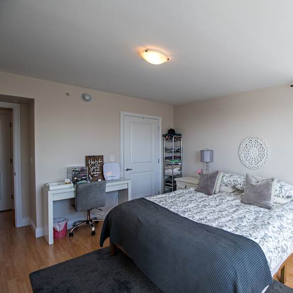 a bedroom with a bed, desk, and chair.