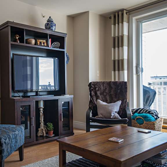 a living room with a television, a chair, and a sofa.