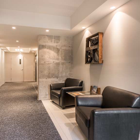 a hallway with a carpeted floor, a stone wall, and a framed picture on the wall.