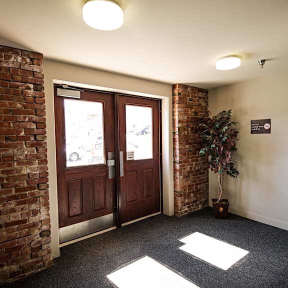a hallway with a brick wall and a door.