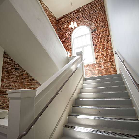 a staircase with a metal railing and a brick wall in the background.