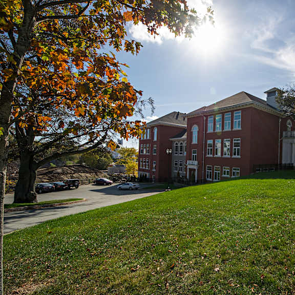 a red brick building with a green lawn in front.