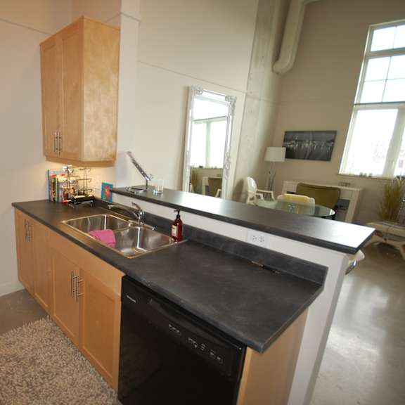 a kitchen with a black counter top and wooden cabinets.
