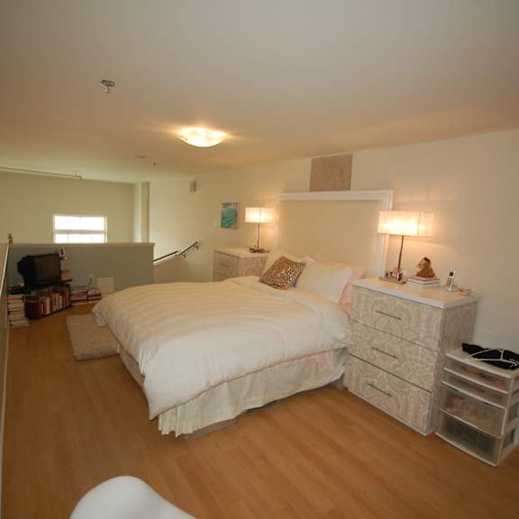 a bedroom with a bed, nightstand, and chair.