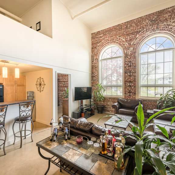 a living room with a brick wall and a large window.