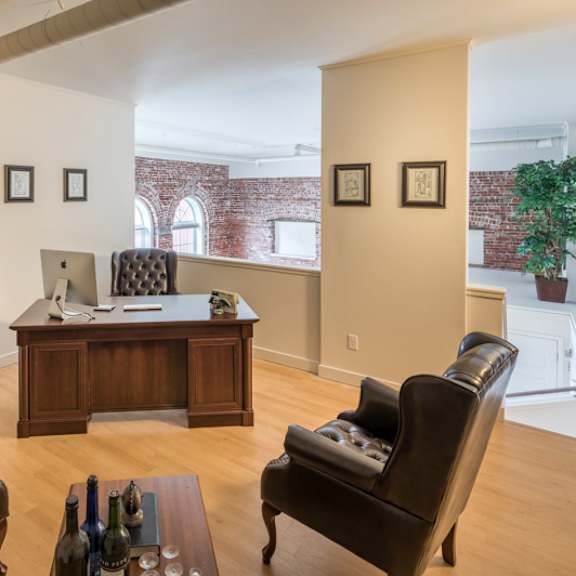 a living room with a brown leather chair and a wooden table.