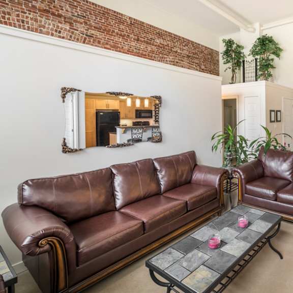 a living room with a brown leather couch and a coffee table.