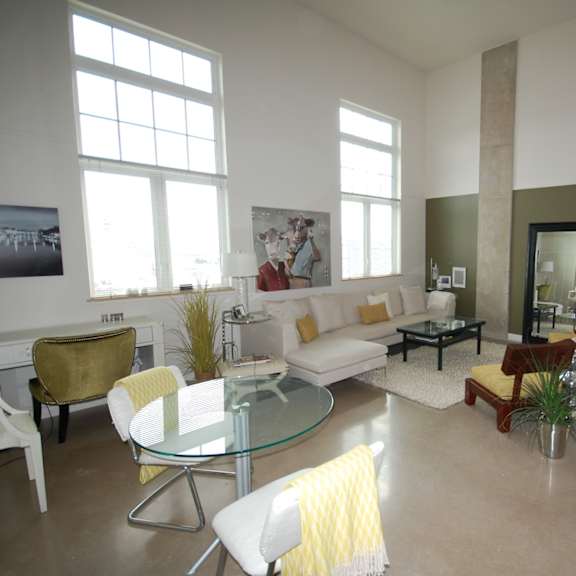 a living room with a glass table and white couches.
