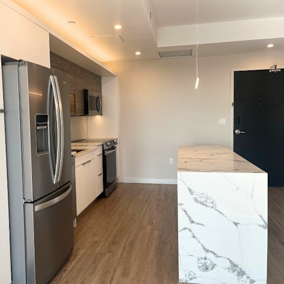 a kitchen with a white fridge and a black door.