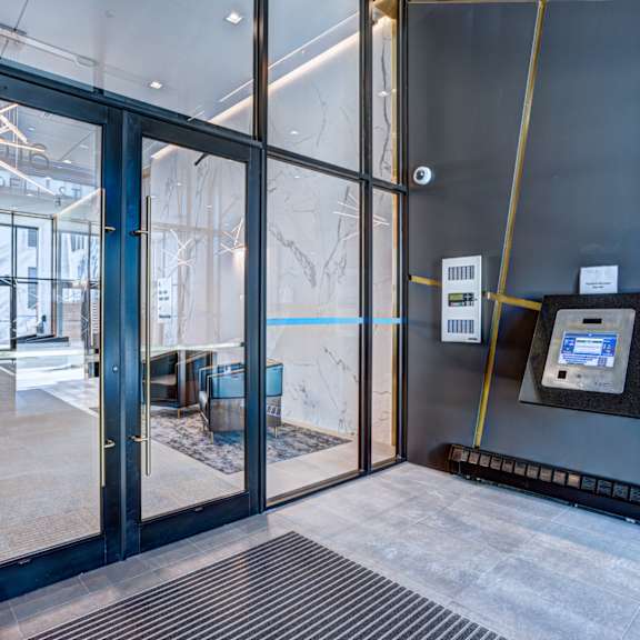 a glass door with a black frame and a black and white sign on the wall.