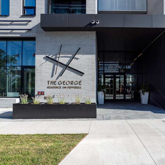 the george hotel entrance with a black and white sign.