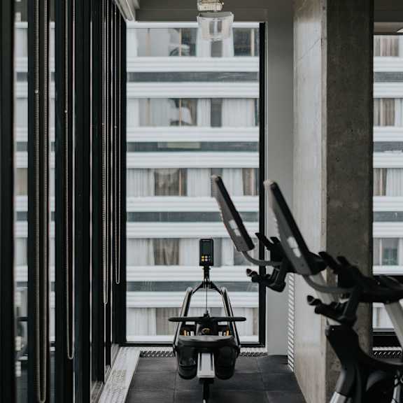 a gym with a treadmill, stationary bike, and weights.