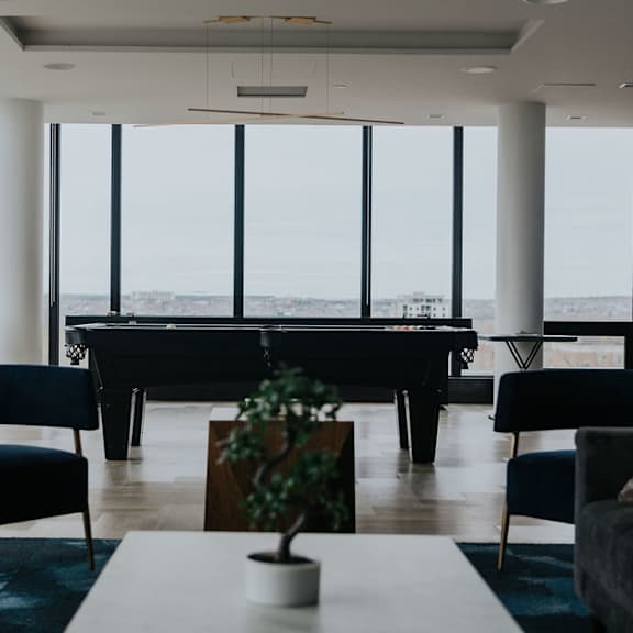 a living room with a piano and a view of the city.