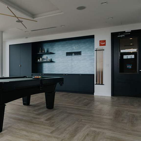 a pool table in a room with a view of the city.