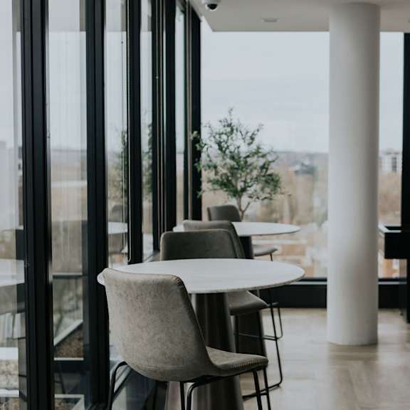 a room with a table and chairs with a view of the city.