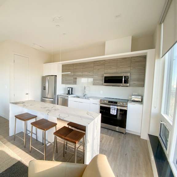 a modern kitchen with a bar area and a dining table.