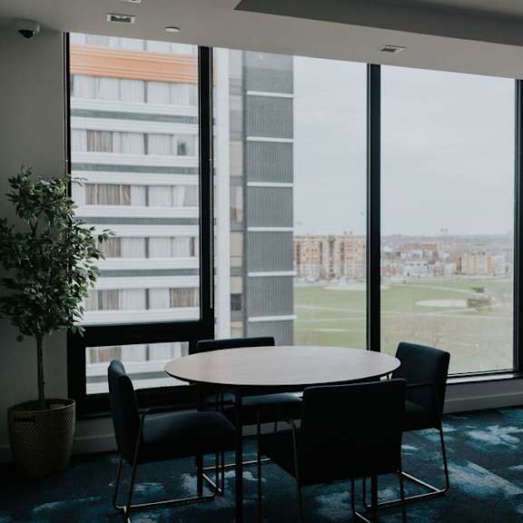a conference room with a table and chairs and a view of a cityscape outside the window.