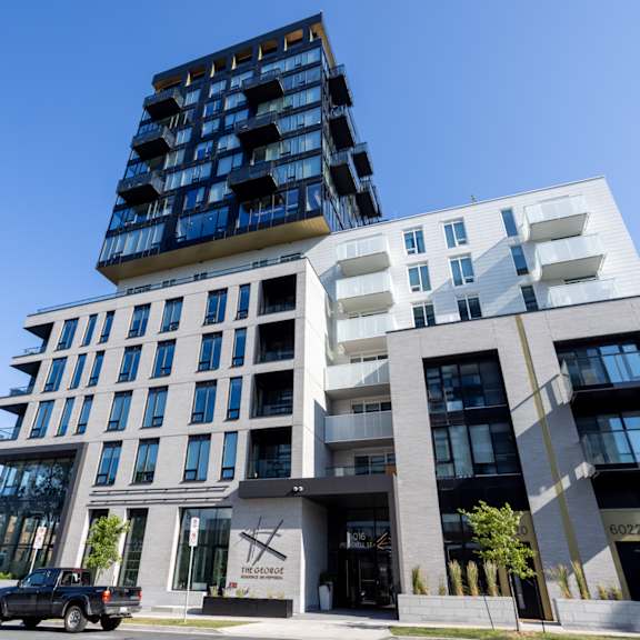 a modern building with a black truck parked in front.