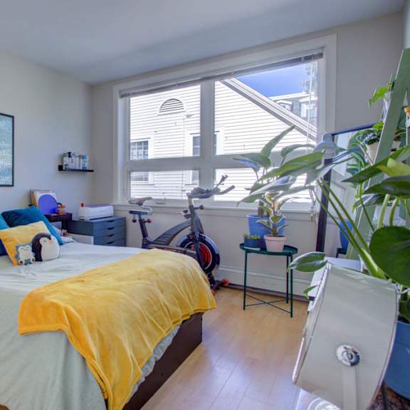 a bedroom with a bed, a chair, and a window.