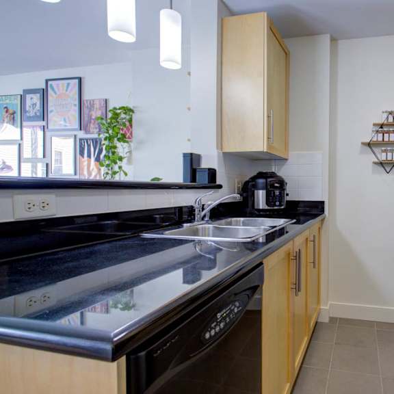 a kitchen with black appliances and wooden cabinets.
