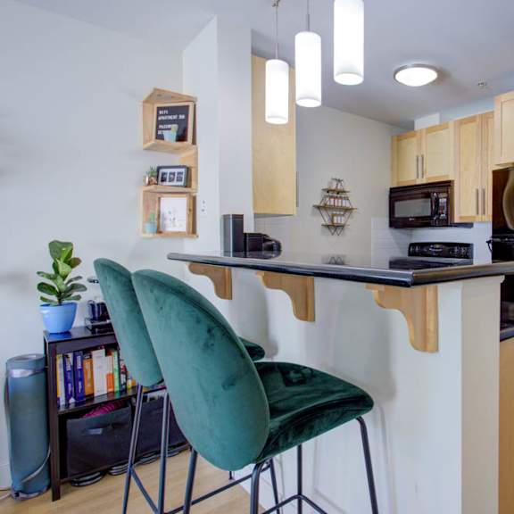 a kitchen with a green chair and a black countertop.