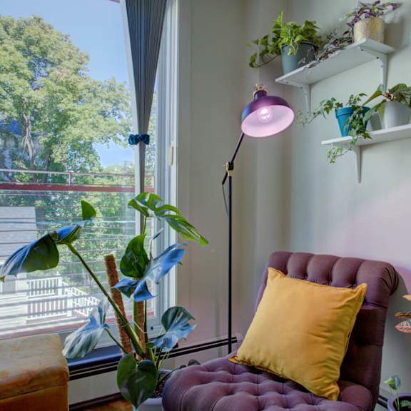 a room with a purple chair and a yellow pillow.
