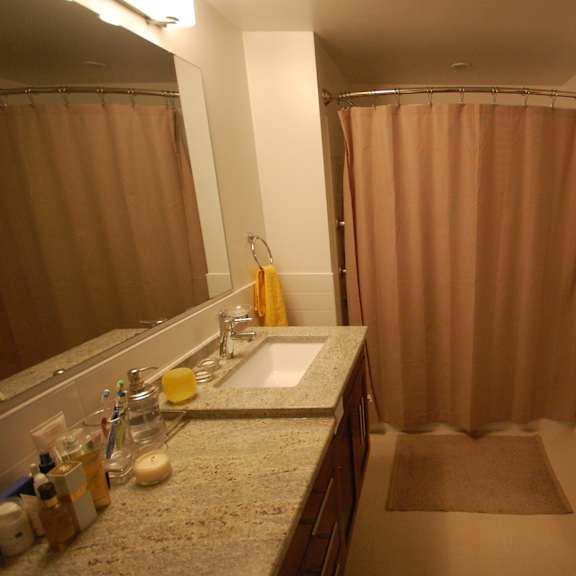 a bathroom with a sink, mirror, and shower curtain.