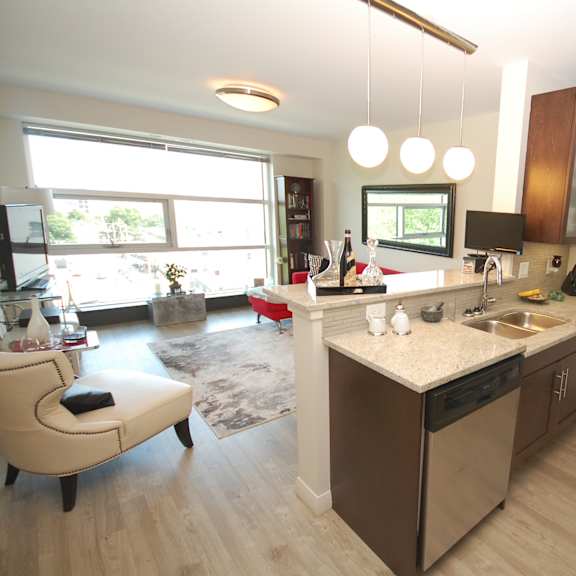 a kitchen with a white counter top and wooden floors.