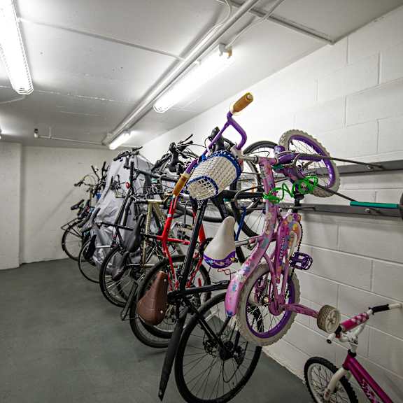 a row of bicycles are parked in a bike rack.