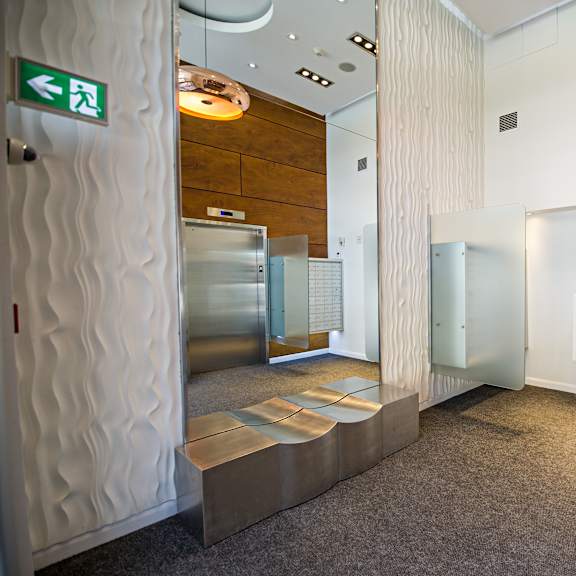 a hallway with a green exit sign on the left.