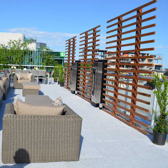 a patio with a row of couches and a wooden fence.