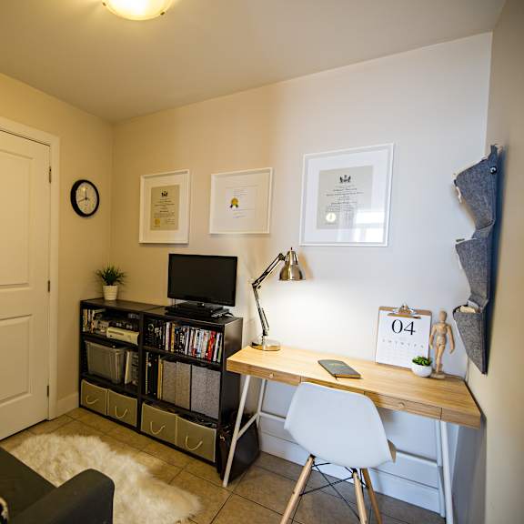 a room with a couch, a desk, and a chair.
