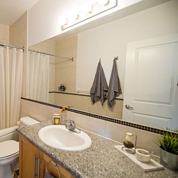 a bathroom with a white toilet, sink, and bathtub.