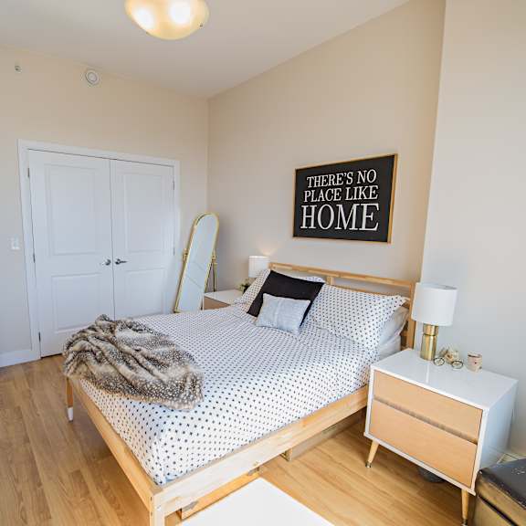 a bedroom with a bed, nightstand, and a mirror.