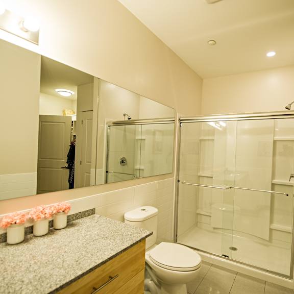 a bathroom with a toilet, sink, and shower.