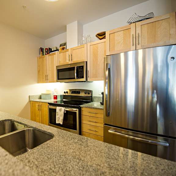 a kitchen with a sink, stove, and refrigerator.