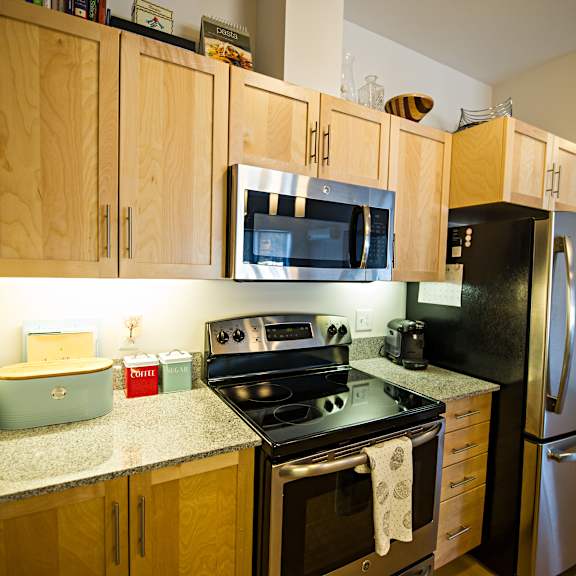 a kitchen with wooden cabinets and a black stove top oven.