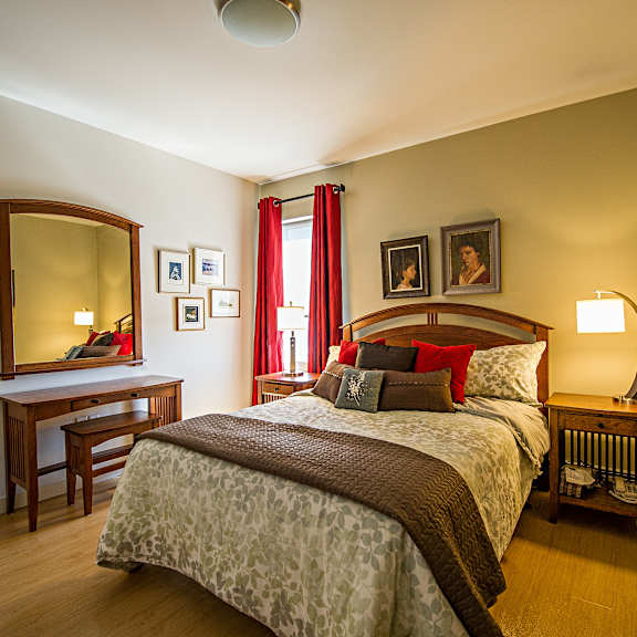 a bedroom with a bed, desk, and chair.