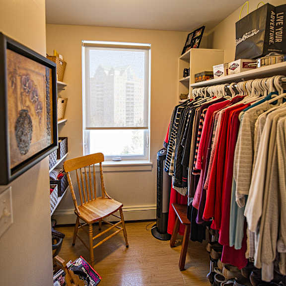 a room with a chair and a rack of clothes.