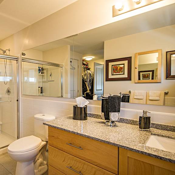 a bathroom with a toilet, sink, and shower.