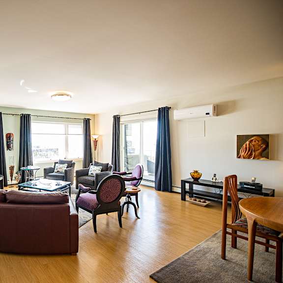 a living room with a brown couch and a wooden floor.