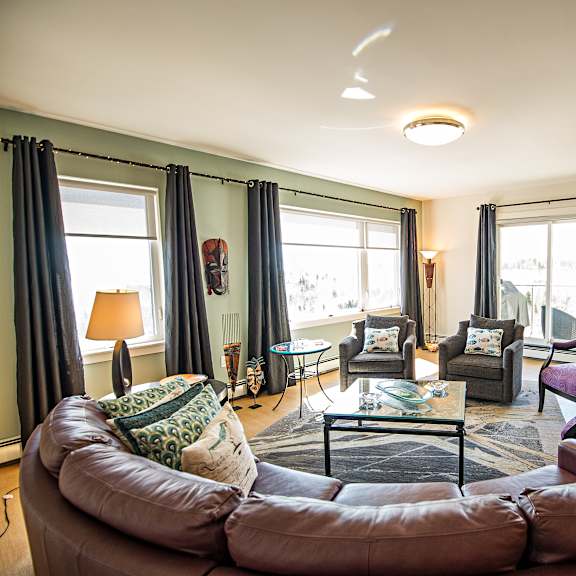 a living room with a brown leather sofa and a glass coffee table.