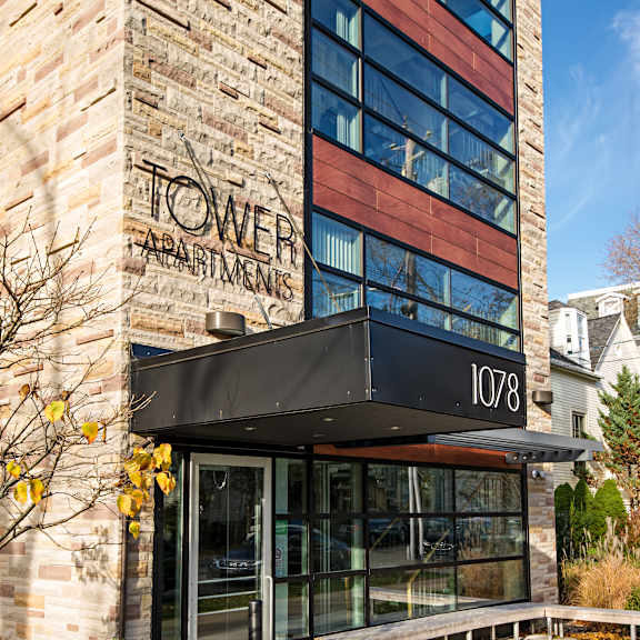 the front of a building with a glass door and a sign that says "tower apartments".